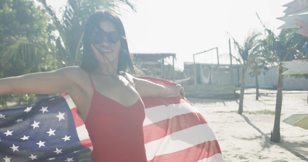 Happy hispanic woman in sunglasses dancing with american flag on sunny beach, slow motion - Free Images, Stock Photos and Pictures on Pikwizard.com