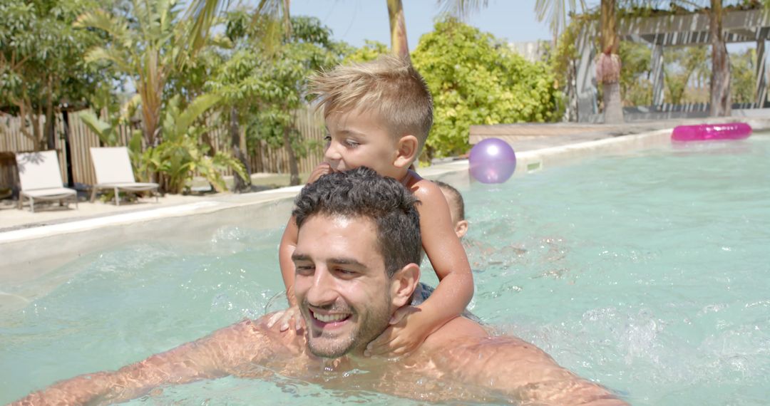 Father and son swimming together in outdoor pool, enjoying summer vacation - Free Images, Stock Photos and Pictures on Pikwizard.com