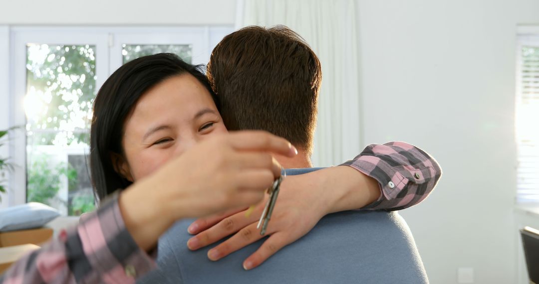 Asian woman embraces a young Caucasian man at home, with copy space - Free Images, Stock Photos and Pictures on Pikwizard.com