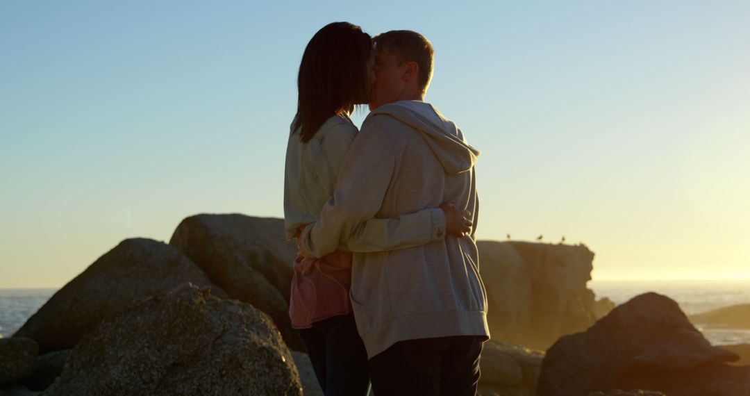 A young Caucasian couple shares a romantic moment at sunset by the sea, with copy space - Free Images, Stock Photos and Pictures on Pikwizard.com