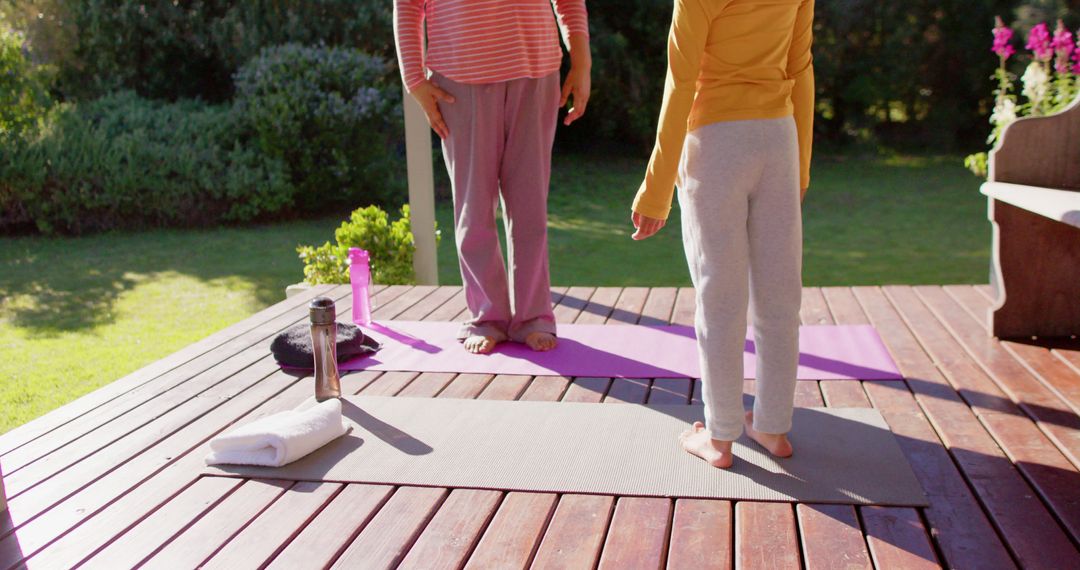 Mother and Daughter Practicing Yoga on Outdoor Deck - Free Images, Stock Photos and Pictures on Pikwizard.com