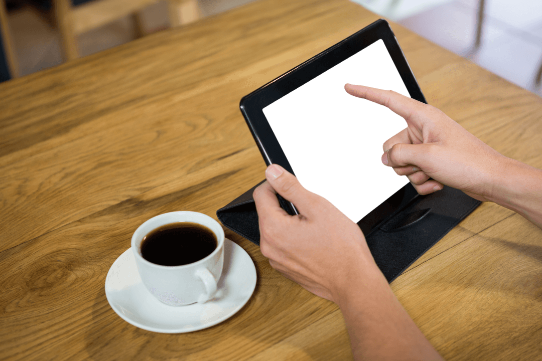 Hands Using a Tablet with Coffee on Transparent Background at Wooden Cafe Table