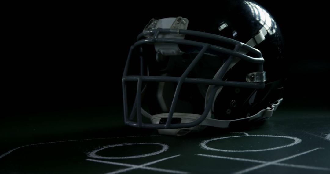 Football Helmet on Chalkboard with Tactical Diagram Under Low Lighting - Free Images, Stock Photos and Pictures on Pikwizard.com