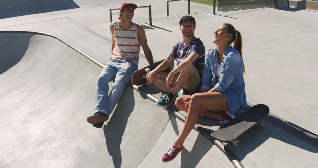 Three friends enjoy a laughter-filled hangout at a skatepark on a sunny summer day. - Free Images, Stock Photos and Pictures on Pikwizard.com