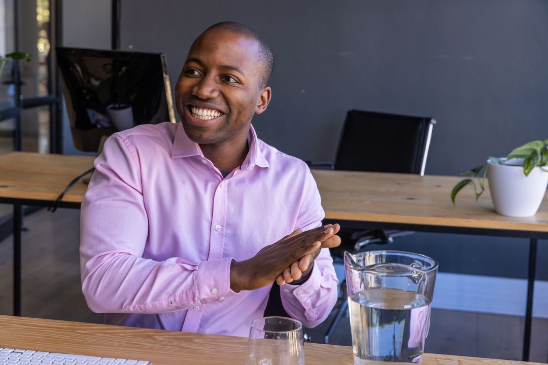 Smiling Man at Office Desk with Pitcher and Glass