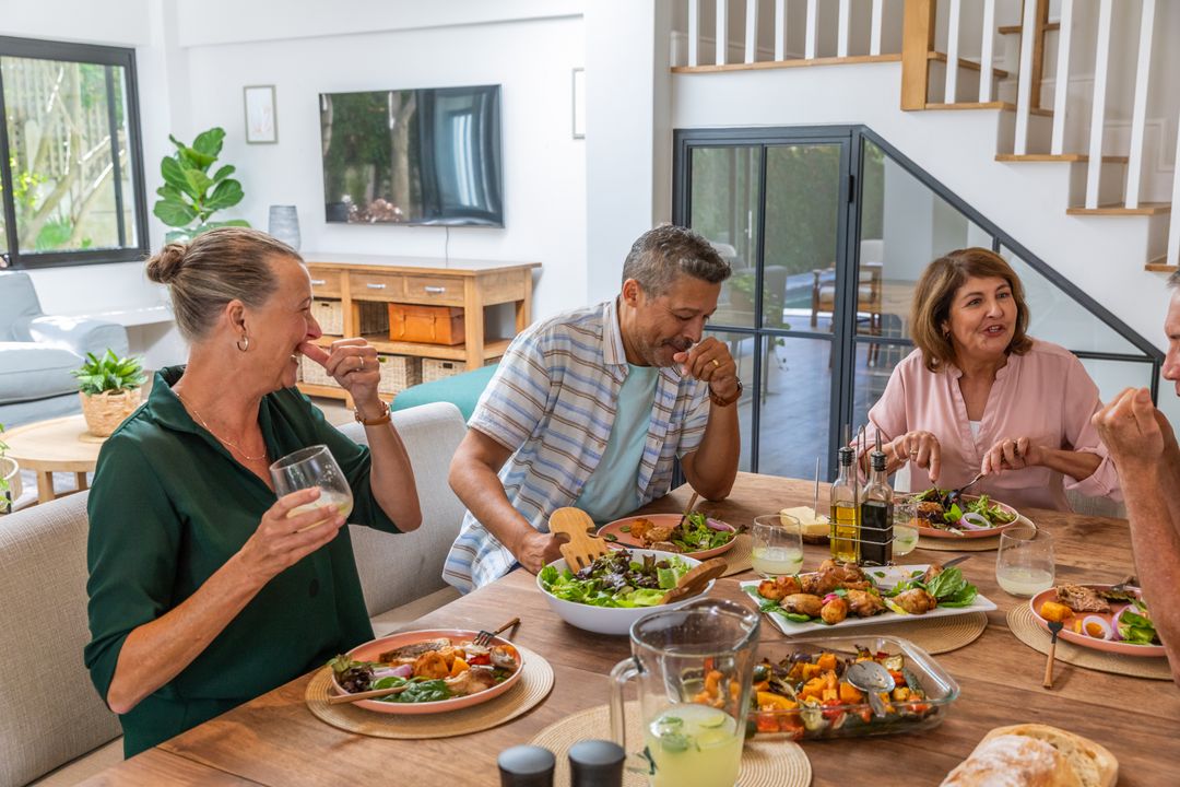 Group of Middle-Aged Friends Enjoying a Lively Meal at Home