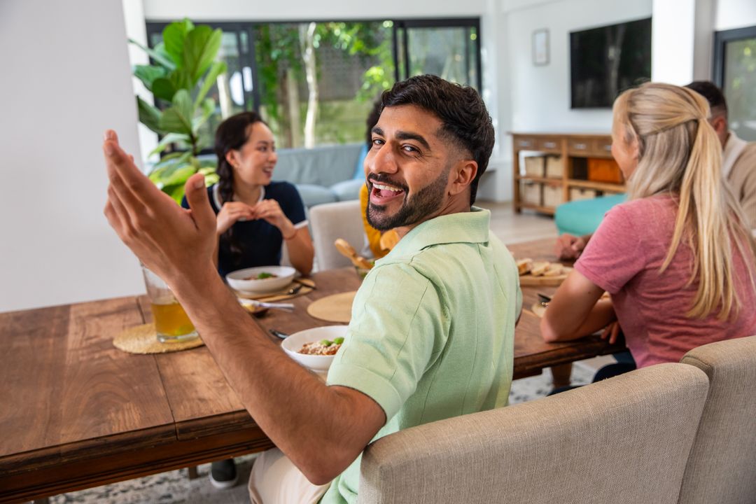 Diverse Friends Enjoying Meal and Socializing at Dining Table