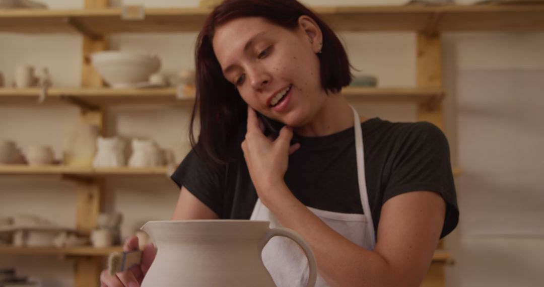 Young Woman Talking on Phone while Sculpting Pottery in Workshop - Free Images, Stock Photos and Pictures on Pikwizard.com