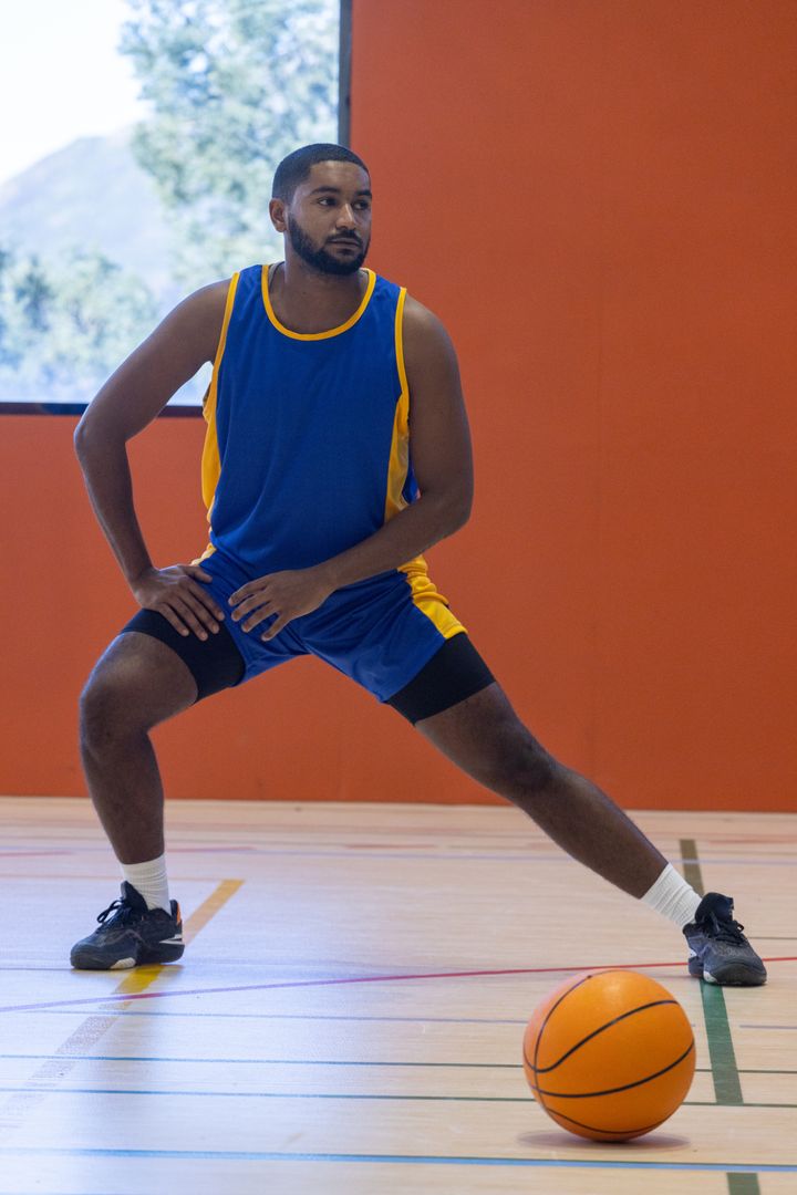 Athlete Stretching on Basketball Court Ready for Game Practice