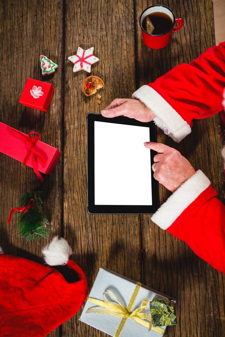 Santa Claus Hands Using Transparent Tablet at Festive Wooden Table - Download Free Stock Images Pikwizard.com