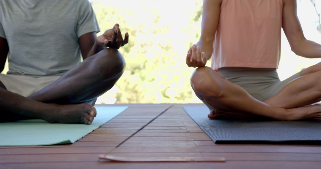 Diverse Couple Meditating on Yoga Mats with Burning Incense