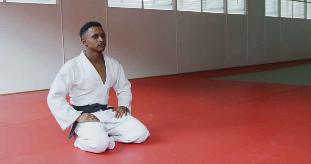 Martial artist meditating on dojo mat - Free Images, Stock Photos and Pictures on Pikwizard.com