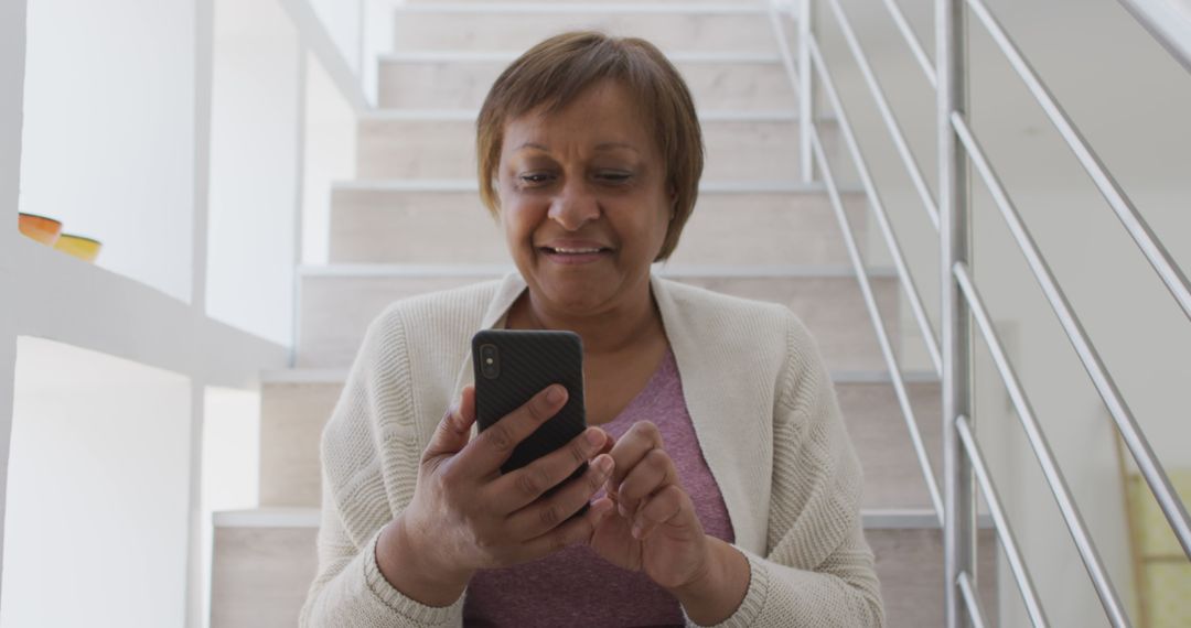 Senior Woman Using Smartphone on Staircase - Free Images, Stock Photos and Pictures on Pikwizard.com