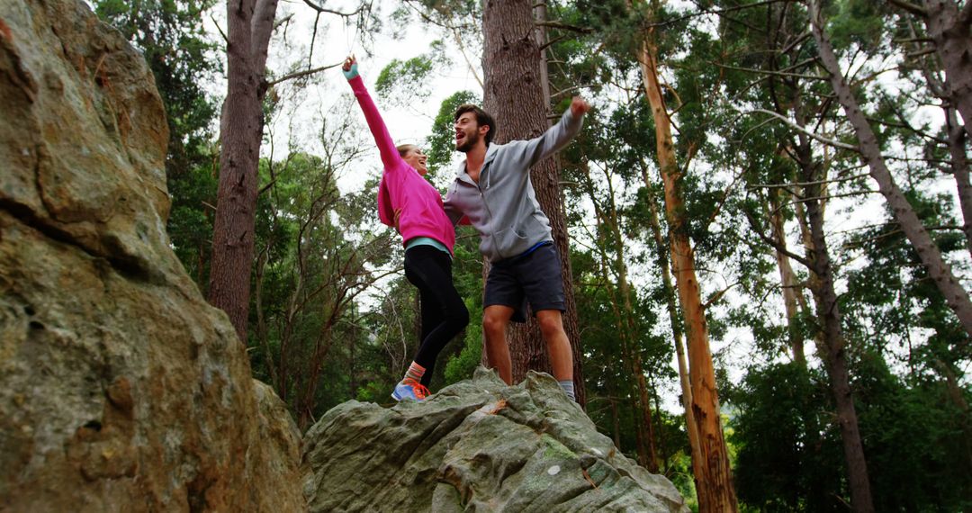 Young Couple Celebrating Top of Rock in Forest - Free Images, Stock Photos and Pictures on Pikwizard.com