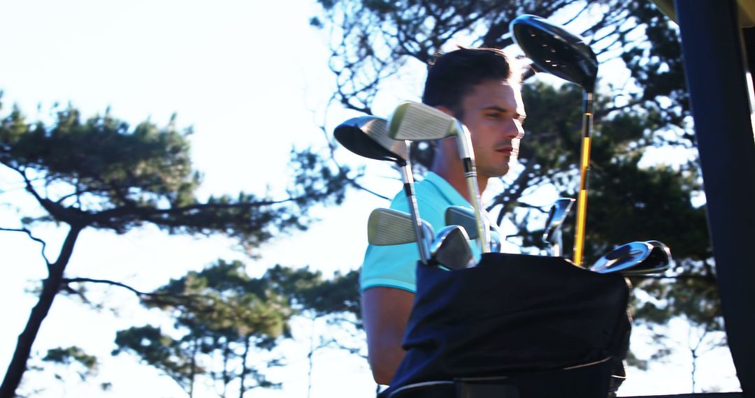 Golfer with Bag of Clubs and Cart on Sunny Course