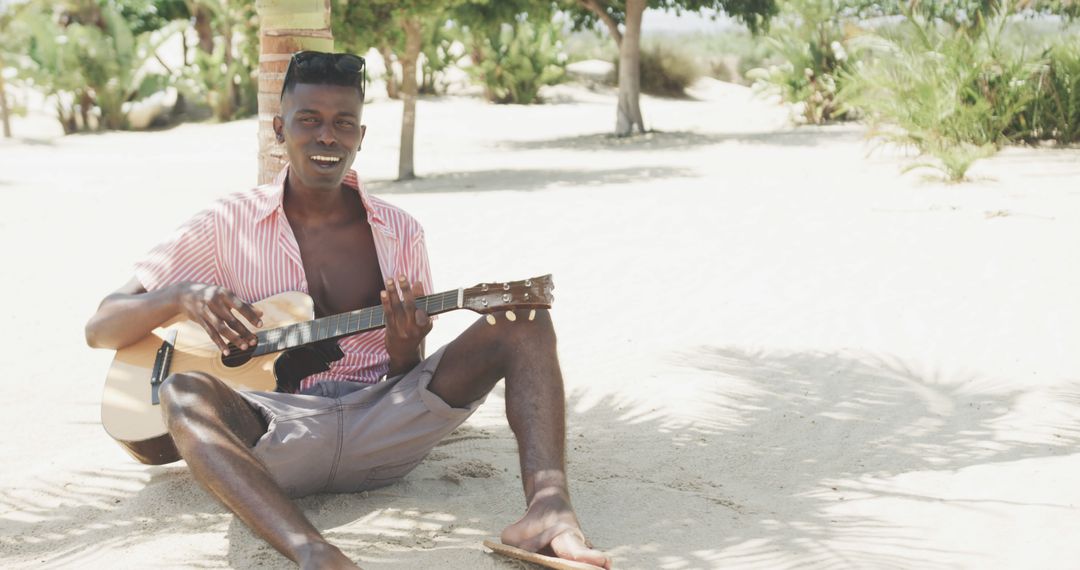 Young Man Playing Guitar Outdoors on Sunny Beach - Free Images, Stock Photos and Pictures on Pikwizard.com