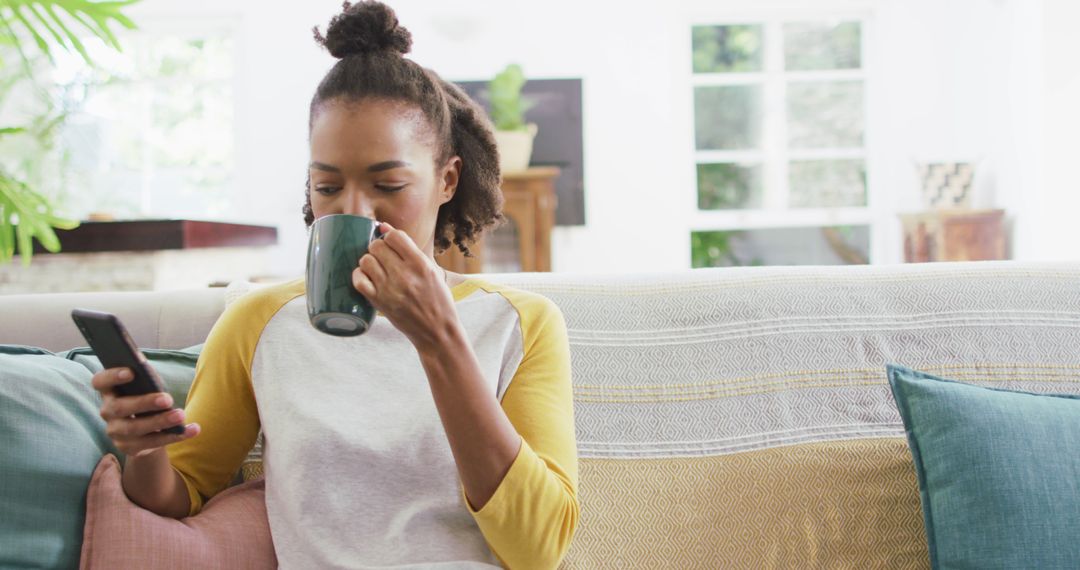 African American Woman Relaxing at Home with Coffee and Smartphone - Free Images, Stock Photos and Pictures on Pikwizard.com