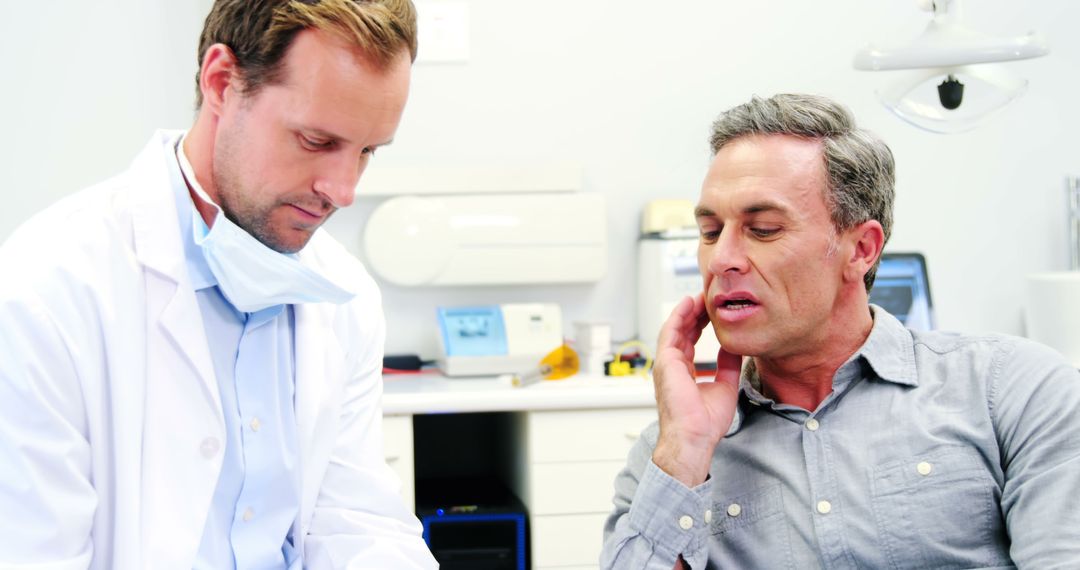 Middle-aged man consulting with doctor in medical office - Free Images, Stock Photos and Pictures on Pikwizard.com