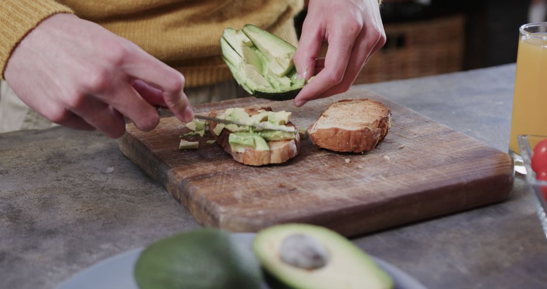 Close-Up of Person Preparing Avocado Toast in Kitchen - Free Images, Stock Photos and Pictures on Pikwizard.com