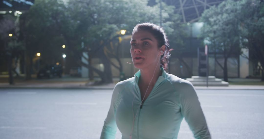 Young Caucasian woman jogging at night in an urban setting - Free Images, Stock Photos and Pictures on Pikwizard.com