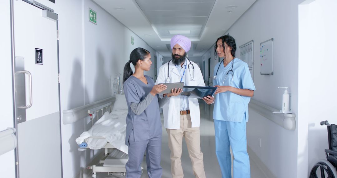 Diverse Medical Team Discussing Patient Records in Hospital Corridor - Free Images, Stock Photos and Pictures on Pikwizard.com