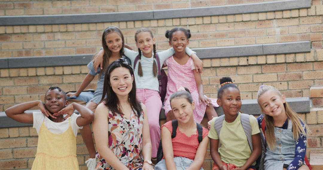 Diverse Teacher and Elementary Students Smiling Joyfully on Brick Steps - Free Images, Stock Photos and Pictures on Pikwizard.com