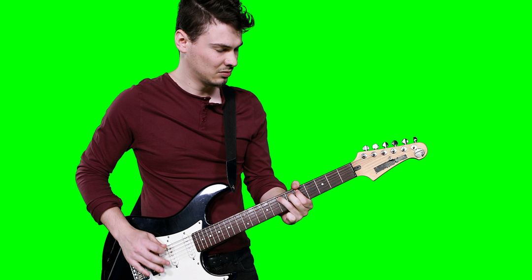 Male musician playing guitar against green screen - Free Images, Stock Photos and Pictures on Pikwizard.com