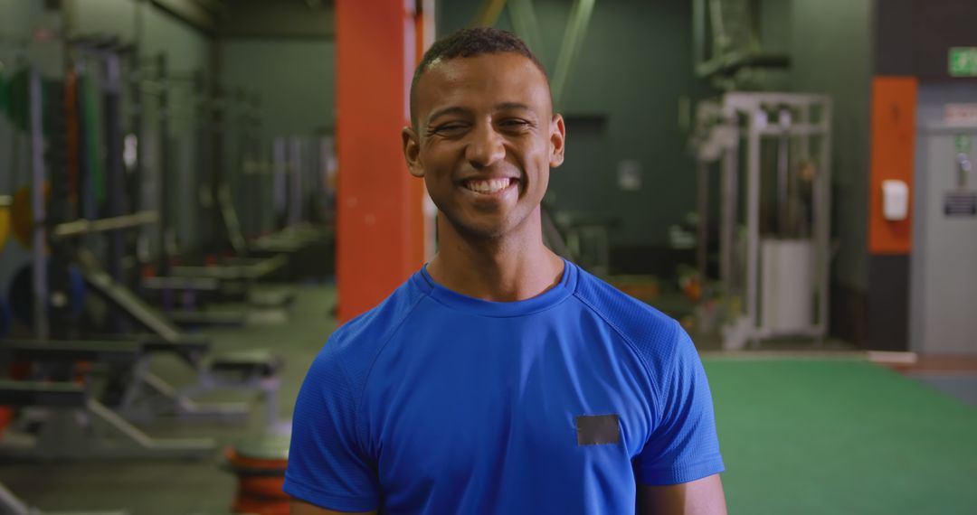 Smiling man in blue shirt at gym facility - Free Images, Stock Photos and Pictures on Pikwizard.com