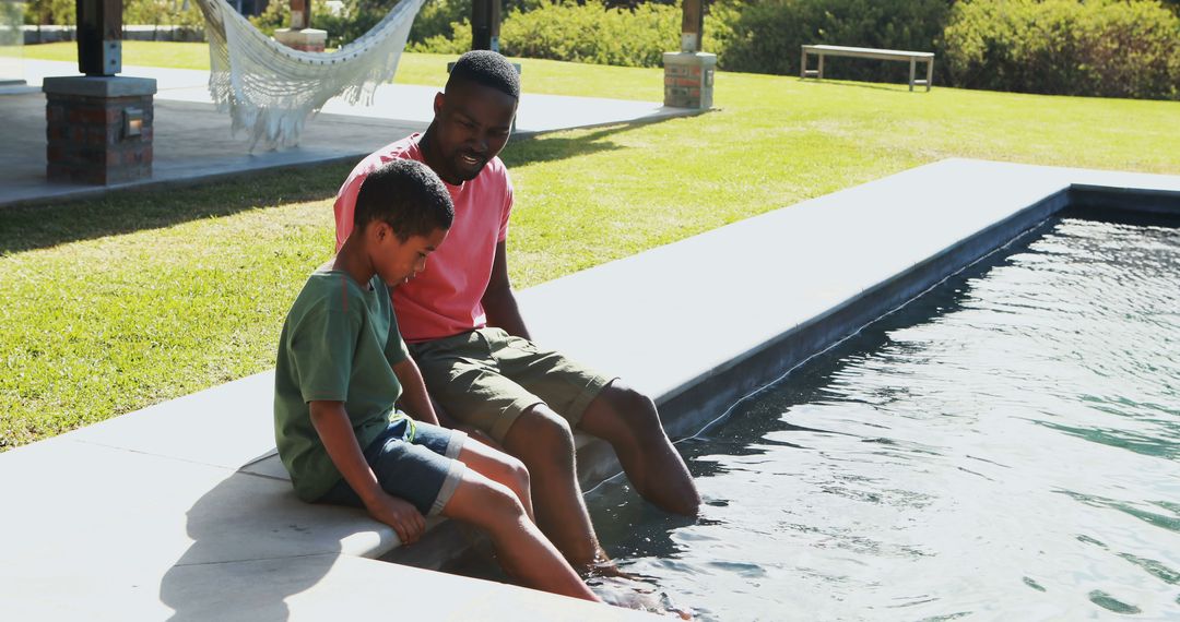 Father and Son Relaxing by Poolside in Serene Outdoor Environment - Free Images, Stock Photos and Pictures on Pikwizard.com