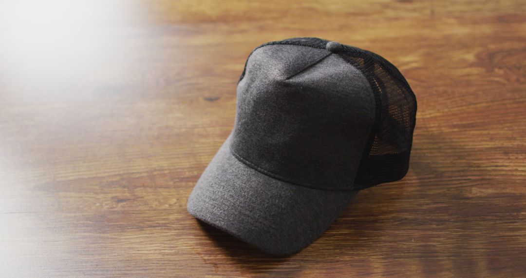 Image of close up of gray baseball cap lying on wooden table - Free Images, Stock Photos and Pictures on Pikwizard.com