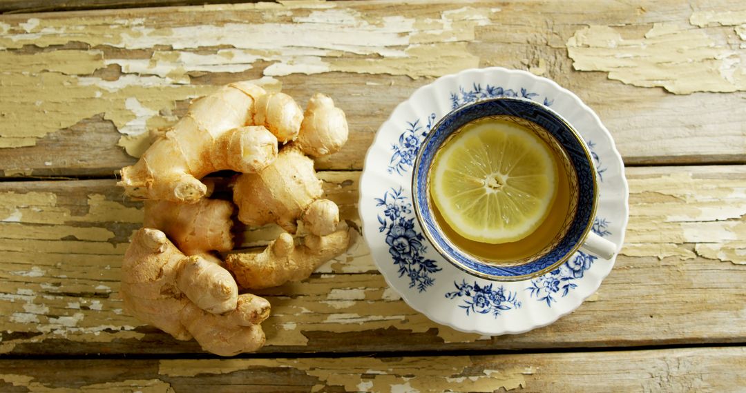 Close up of fresh ginger and cup of tea with lemon on wooden table - Free Images, Stock Photos and Pictures on Pikwizard.com