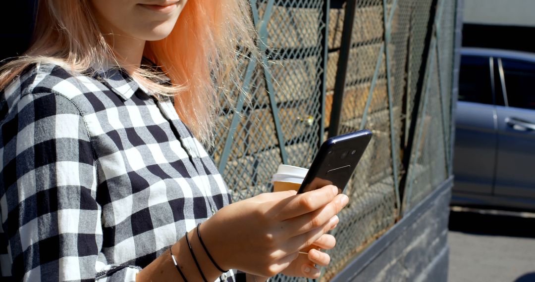 Young Woman Texting on Smartphone While Holding Coffee Cup Outdoors - Free Images, Stock Photos and Pictures on Pikwizard.com