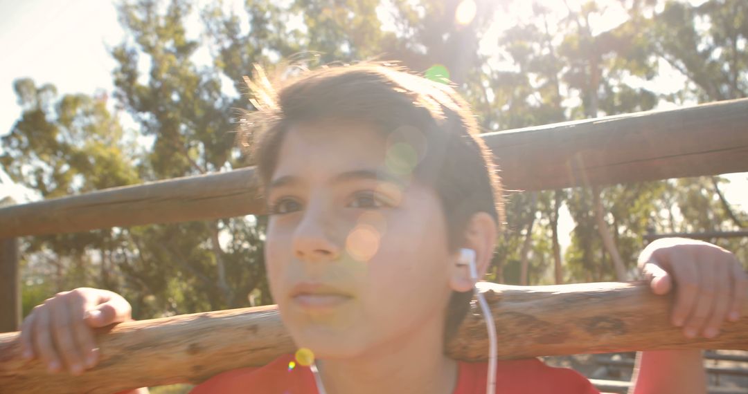 Young Boy Enjoying Outdoors with Earphones in Sunlight - Free Images, Stock Photos and Pictures on Pikwizard.com