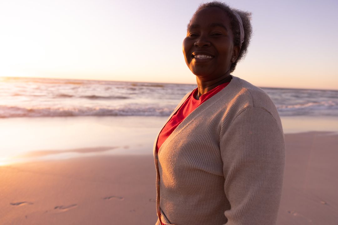 Smiling Senior African American Woman Enjoying Beach at Sunset - Free Images, Stock Photos and Pictures on Pikwizard.com