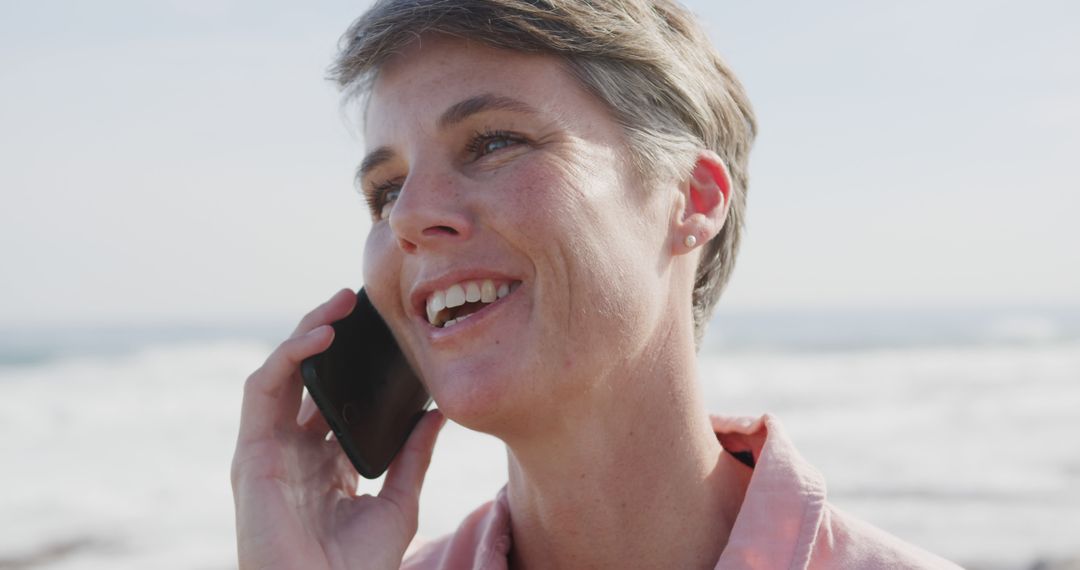 Smiling Woman Talking on Phone at Beach - Free Images, Stock Photos and Pictures on Pikwizard.com