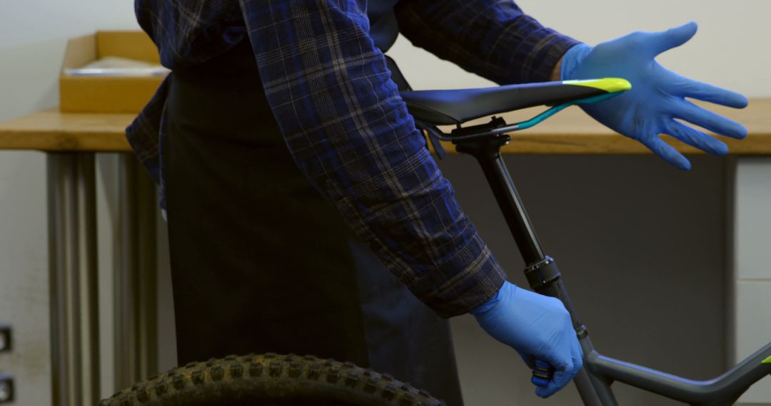 Bicycle Mechanic Repairing Bike with Blue Gloves in Workshop - Free Images, Stock Photos and Pictures on Pikwizard.com