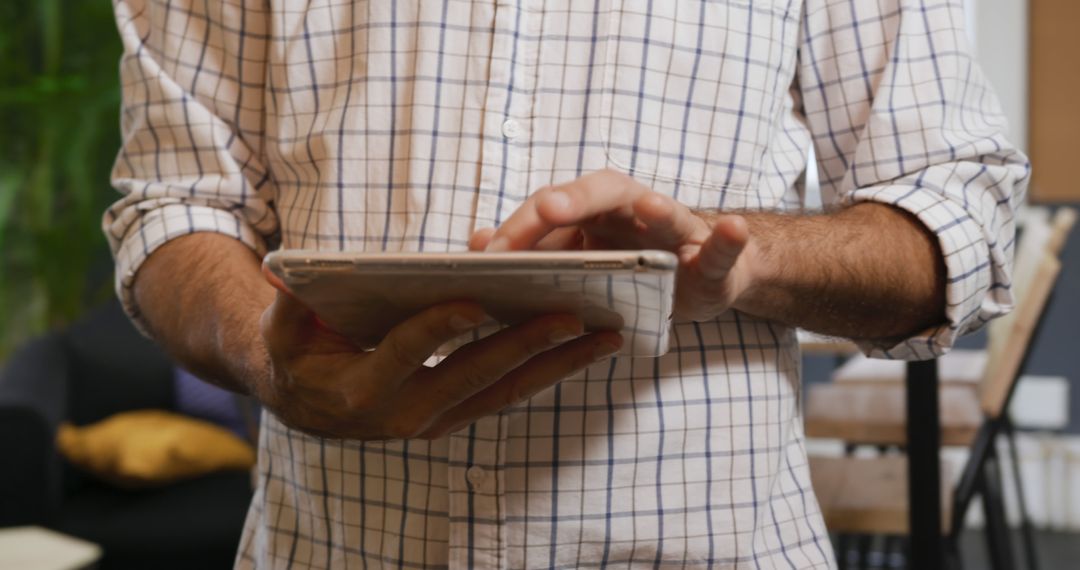 Man Wearing Plaid Shirt Using Digital Tablet in Office Setting - Free Images, Stock Photos and Pictures on Pikwizard.com