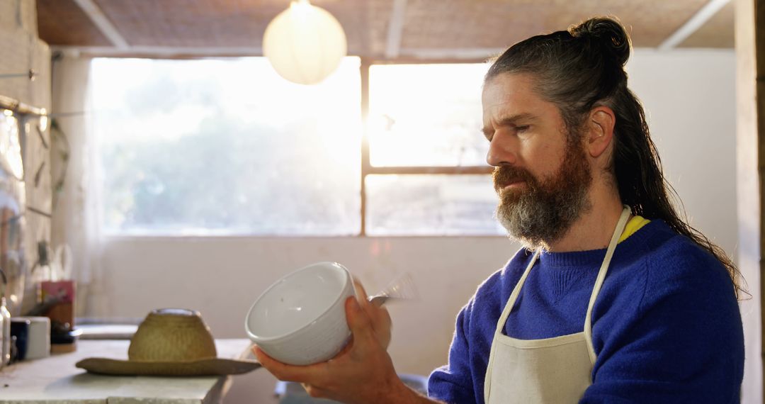 Middle-aged Man in Apron Inspecting Ceramic Bowl in Crafts Workshop - Free Images, Stock Photos and Pictures on Pikwizard.com