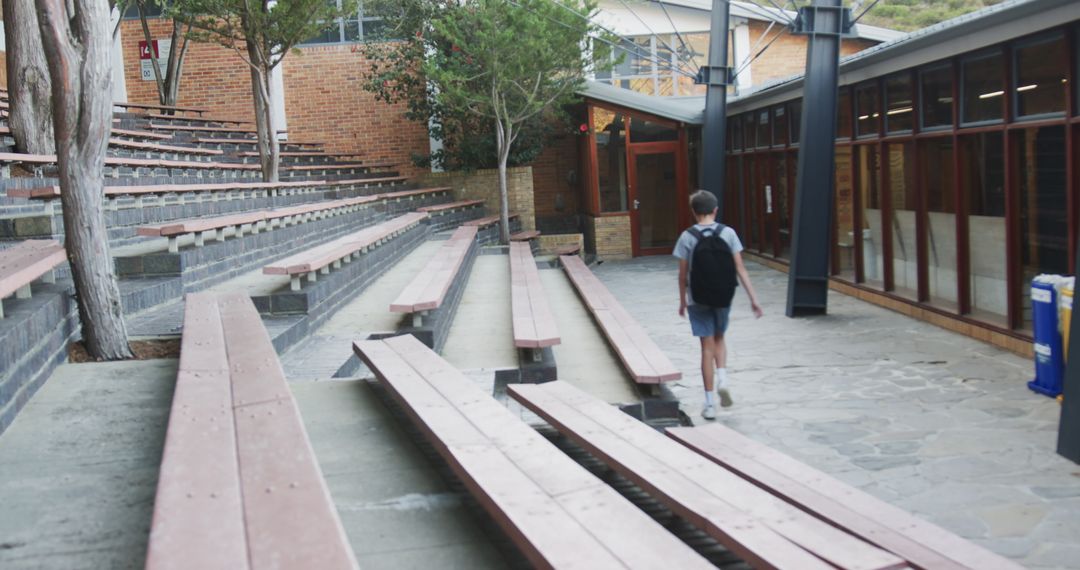 Schoolboy Walking Through Campus Courtyard with Backpacks Heading to Classrooms