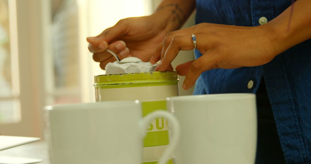 Woman Adding Sugar to Mugs in Bright Kitchen - Free Images, Stock Photos and Pictures on Pikwizard.com