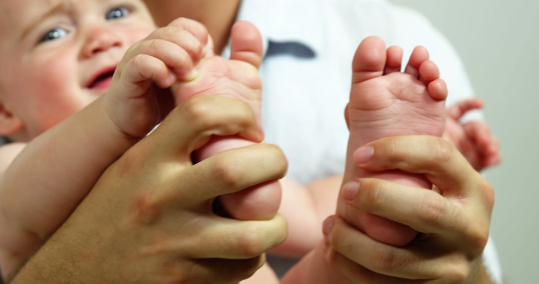 Close-Up of Adult Hands Cradling Infant Feet - Free Images, Stock Photos and Pictures on Pikwizard.com