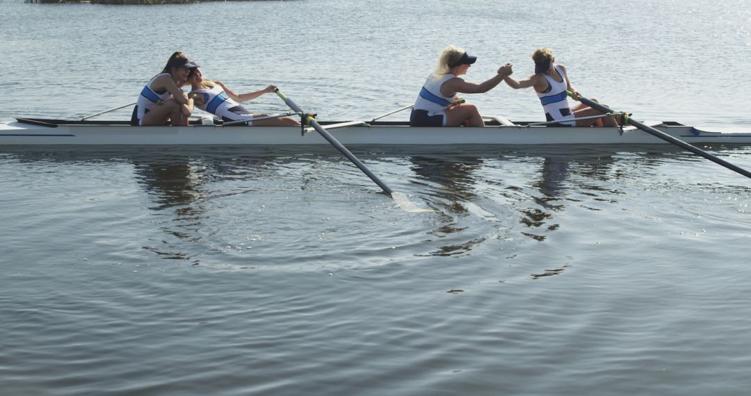 Women's rowing team celebrating during outdoor practice on lake - Free Images, Stock Photos and Pictures on Pikwizard.com