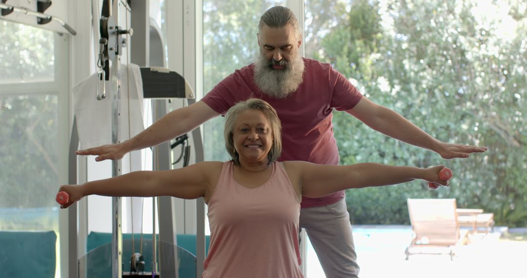 Senior Couple Exercising with Dumbbells Together