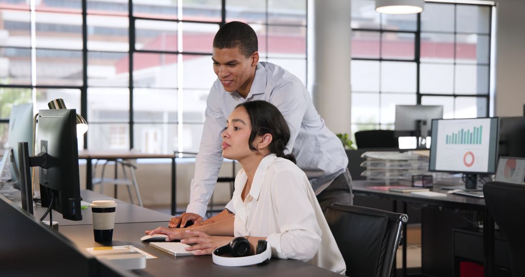 Coworkers Collaborating on Project in Modern Office Environment