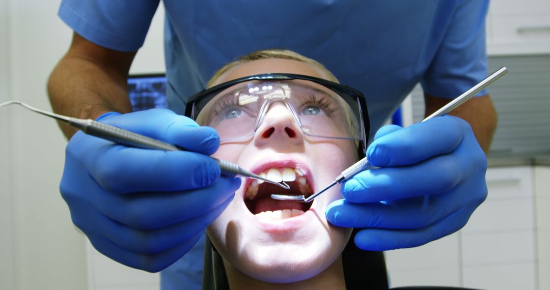 Young Boy Receiving Dental Treatment by Professional Dentist - Free Images, Stock Photos and Pictures on Pikwizard.com