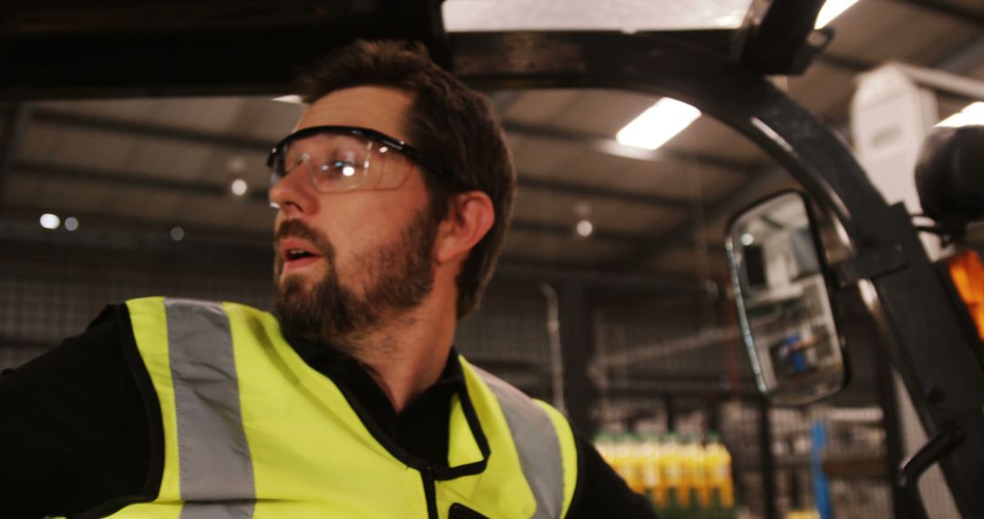 Warehouse Worker Operating Forklift with Safety Vest and Glasses - Free Images, Stock Photos and Pictures on Pikwizard.com