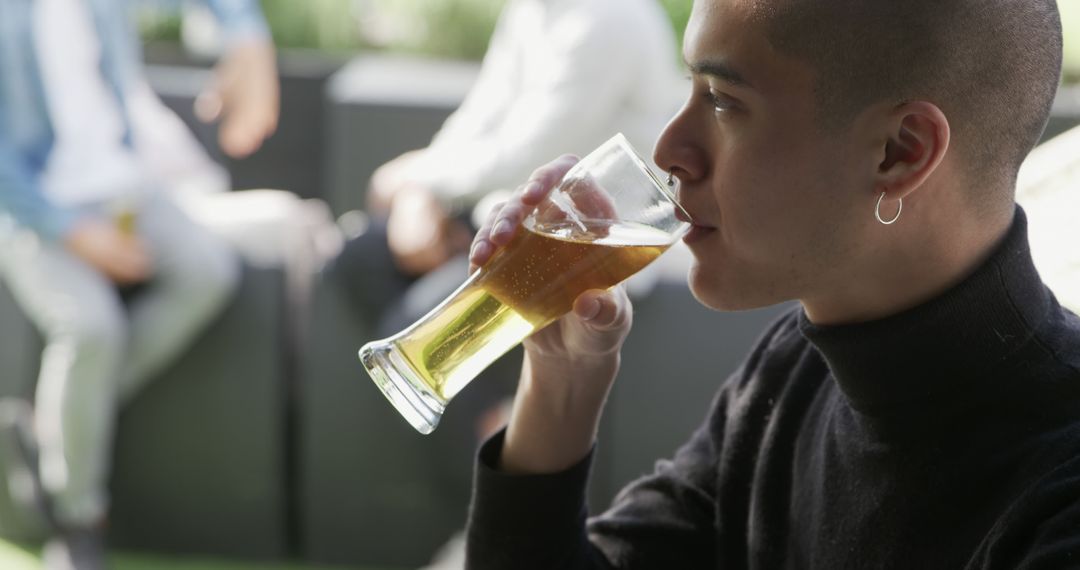 Young Man Enjoying Craft Beer on Outdoor Patio - Free Images, Stock Photos and Pictures on Pikwizard.com