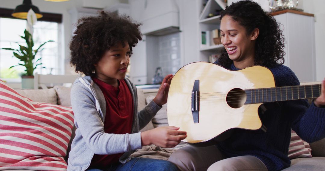 Mother Teaching Young Son to Play Acoustic Guitar at Home - Free Images, Stock Photos and Pictures on Pikwizard.com