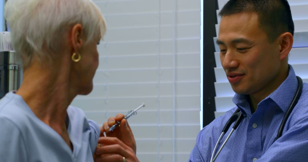 Doctor administering vaccine to senior female patient in medical clinic - Free Images, Stock Photos and Pictures on Pikwizard.com