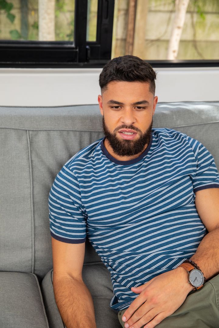 Bearded Man Relaxing on Sofa in Modern Living Room